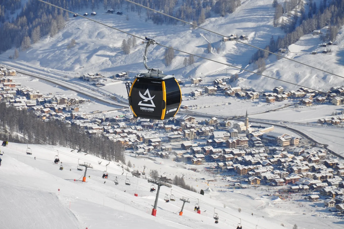 Livigno in Italy - a ski lift in the air above a village.