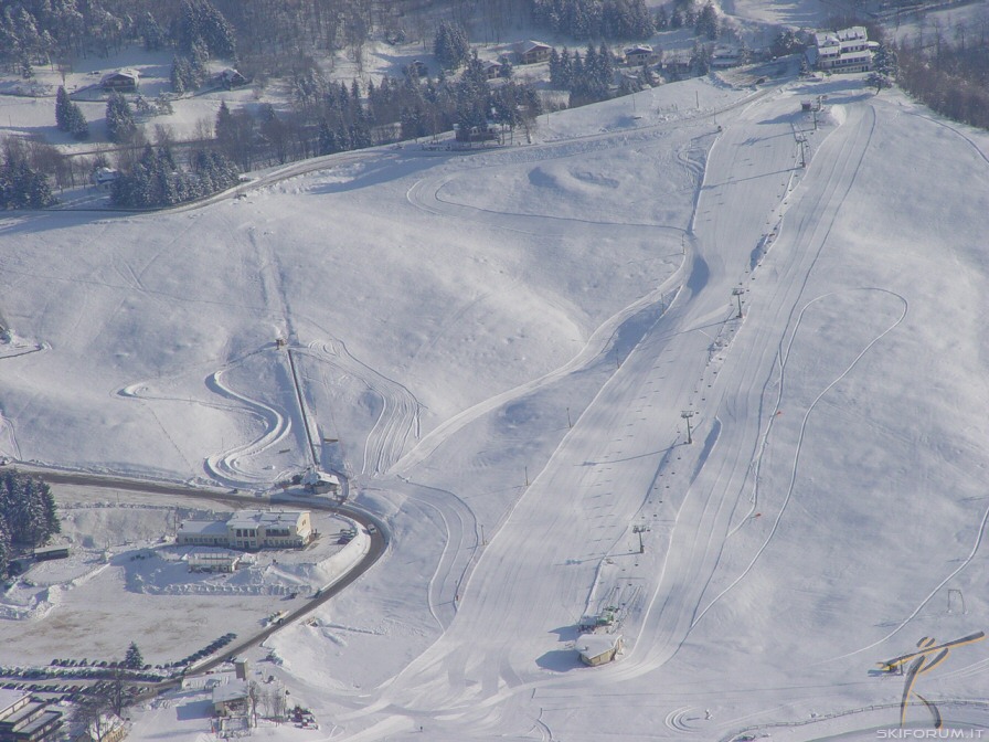 A scenic view of the Recoaro Mille ski resort in Vicenza Italy showcasing snow-covered slopes a ski lift and the bustling activity of the winter sports centre.