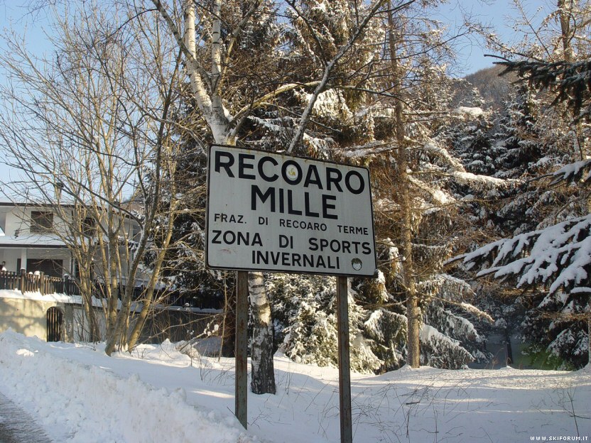 View of a charming chalet in Recoaro Mille, Vicenza during winter amidst a bustling ski resort. Various winter sports activities are in progress showcasing the beautiful winter landscape.