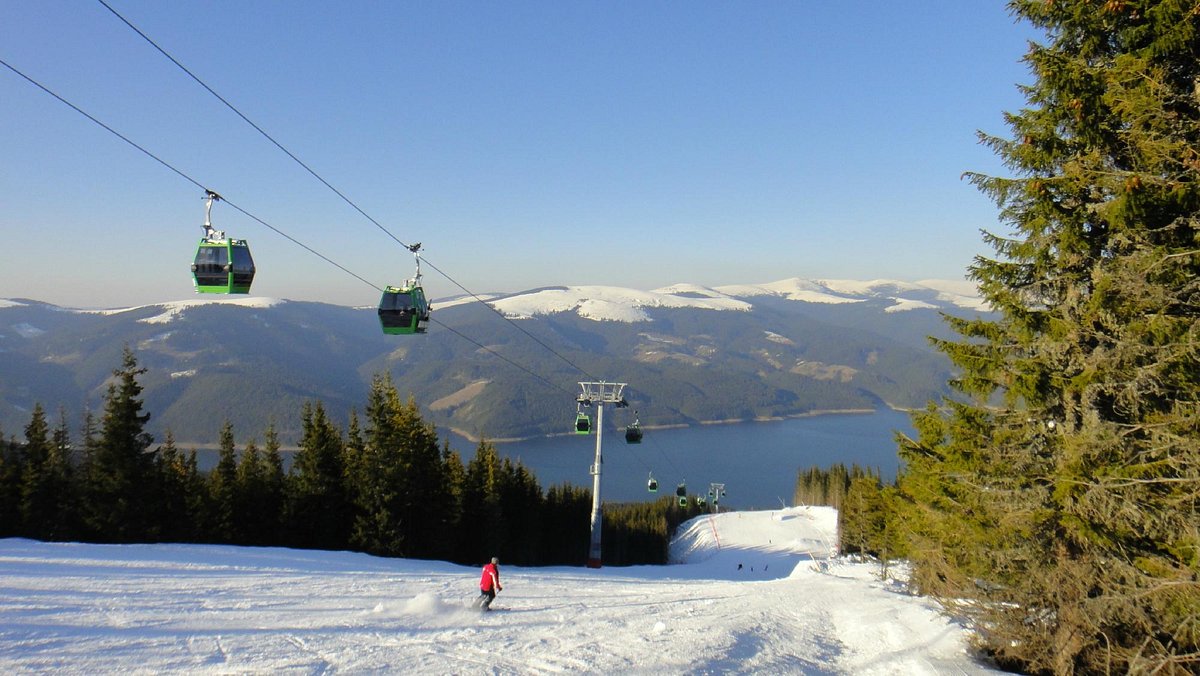 Transalpina – Vidra - Voineasa in Romania - a ski lift going up a snowy slope.