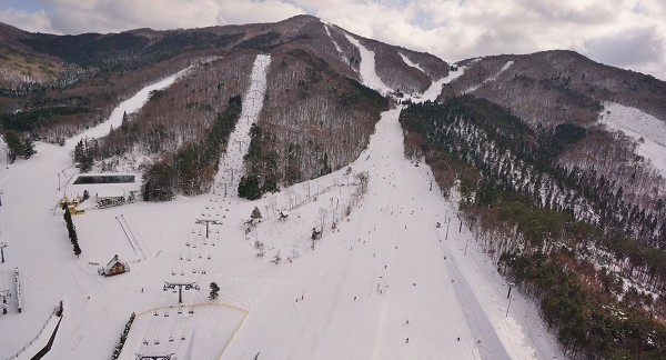 At Utopia Saioto ski resort in Japan snow-covered slopes dot the winter landscape. Skiers make the most of the pristine conditions while ski lifts patiently transport more winter sports enthusiasts uphill.