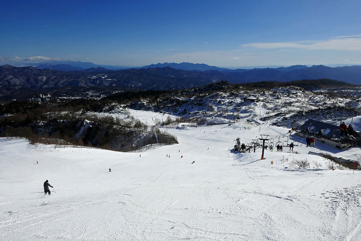 Kusatsu Onsen in Japan - a group of people skiing down a snowy slope.