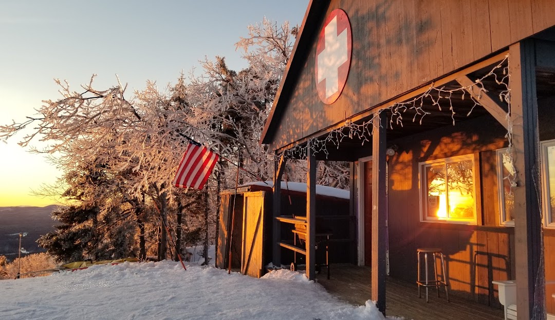 Winter sports enthusiasts enjoying the snow-covered slopes of Crotched Mountain, New Hampshire, with the lodge and charming chalet nestled amidst stunning winter scenery.