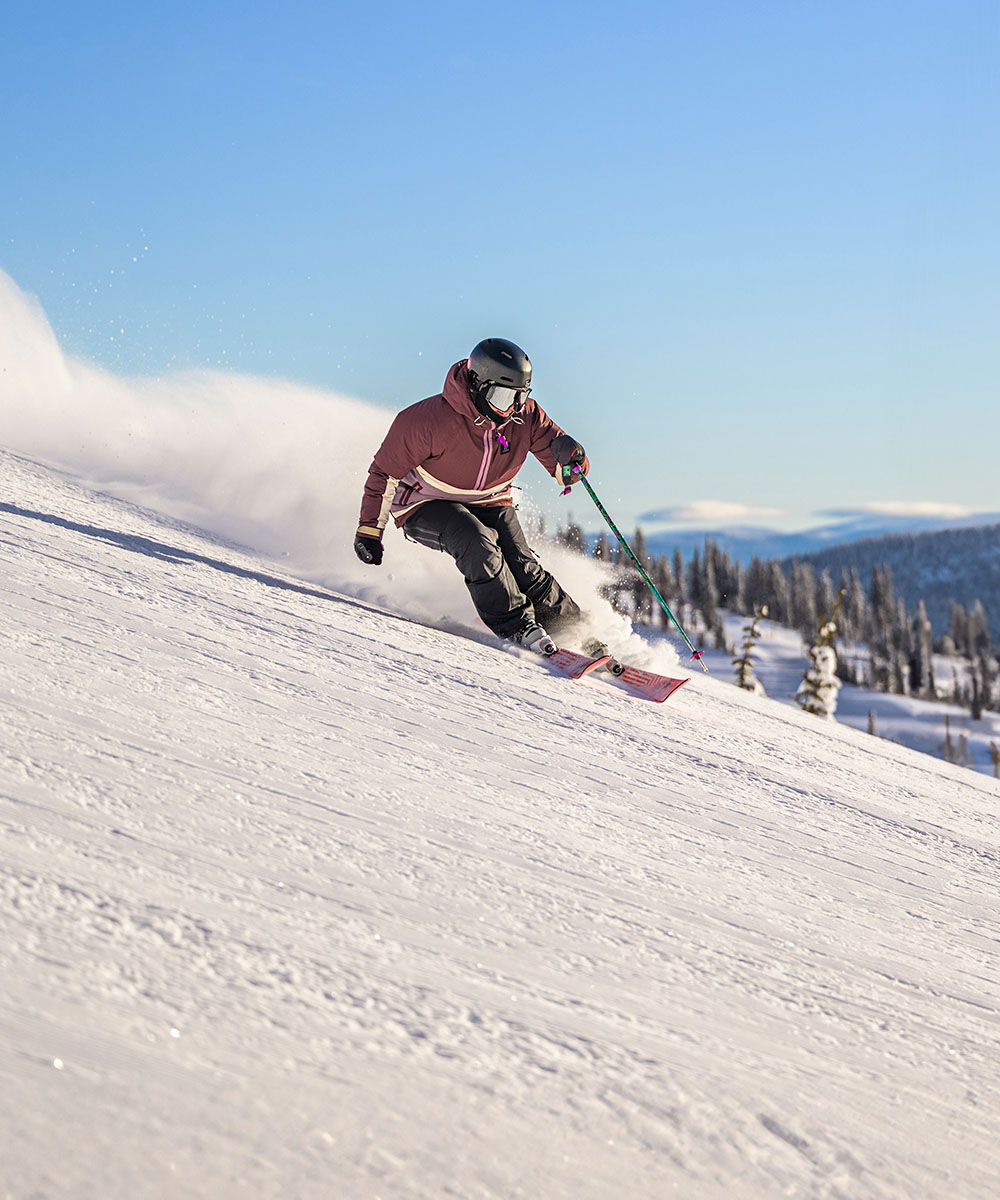 Big White in Canada - a person skiing down a hill on a sunny day.