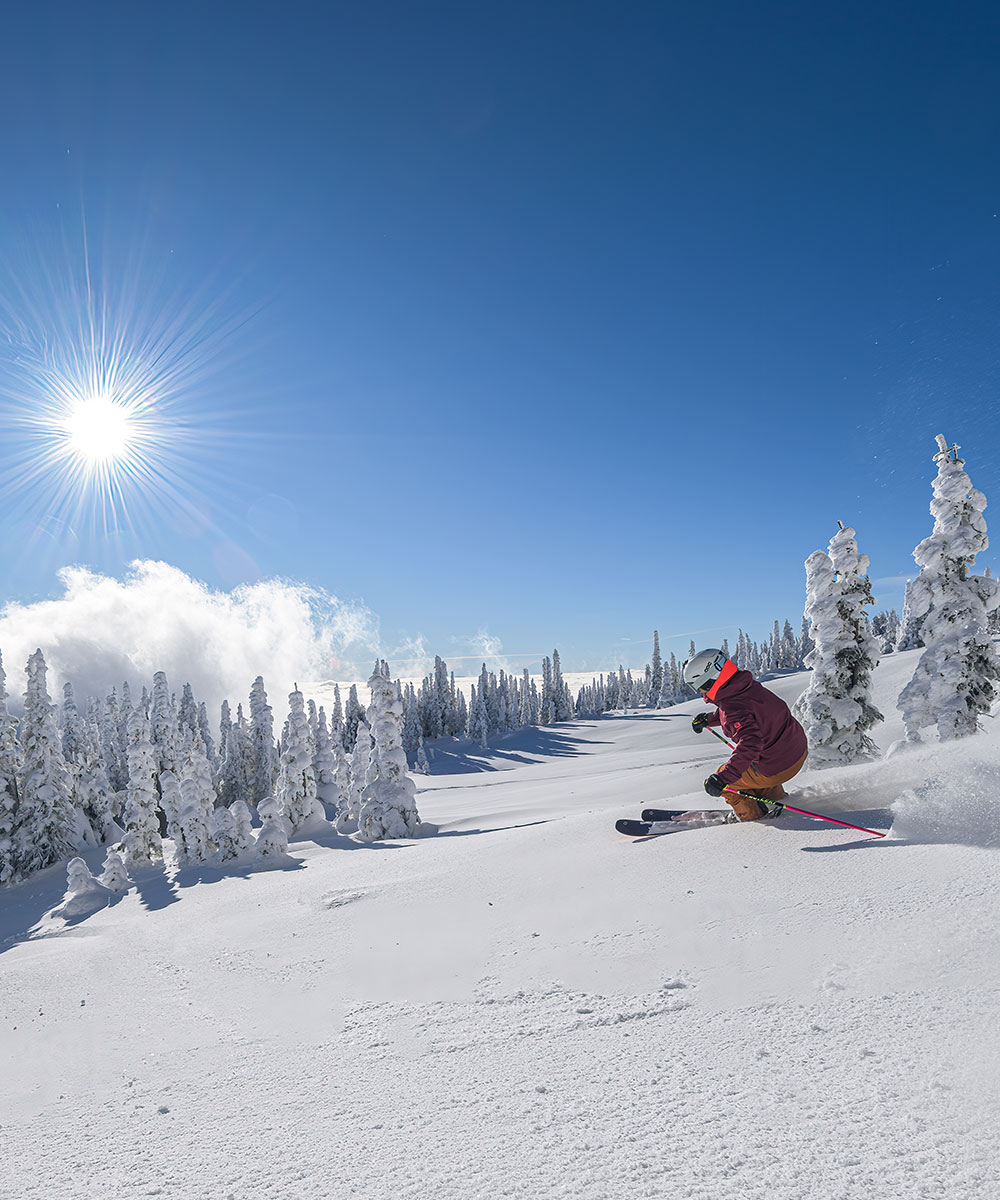 Big White in Canada - a person riding a snowboard down a snowy slope.