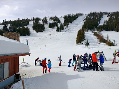 Winter setting at Loup Loup Ski Bowl in Washington, USA, with guests enjoying skiing activities. Visible elements include a ski resort, bustling ski lift, and active winter sports scene.