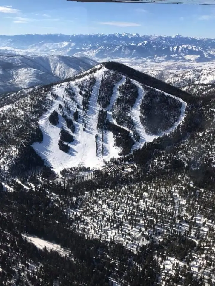 A skier enjoys the snow-covered slopes at Loup Loup Ski Bowl in Okanogan, Washington, on a clear day. Featuring a bustling ski resort nestled amidst beautiful mountainous landscapes.