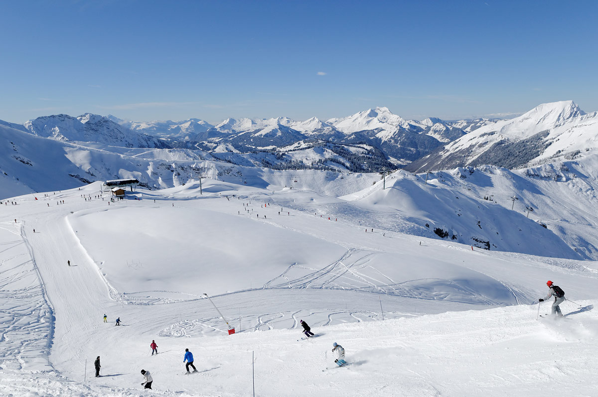 Les Portes du Soleil in Switzerland - a group of people skiing down a snow covered mountain.