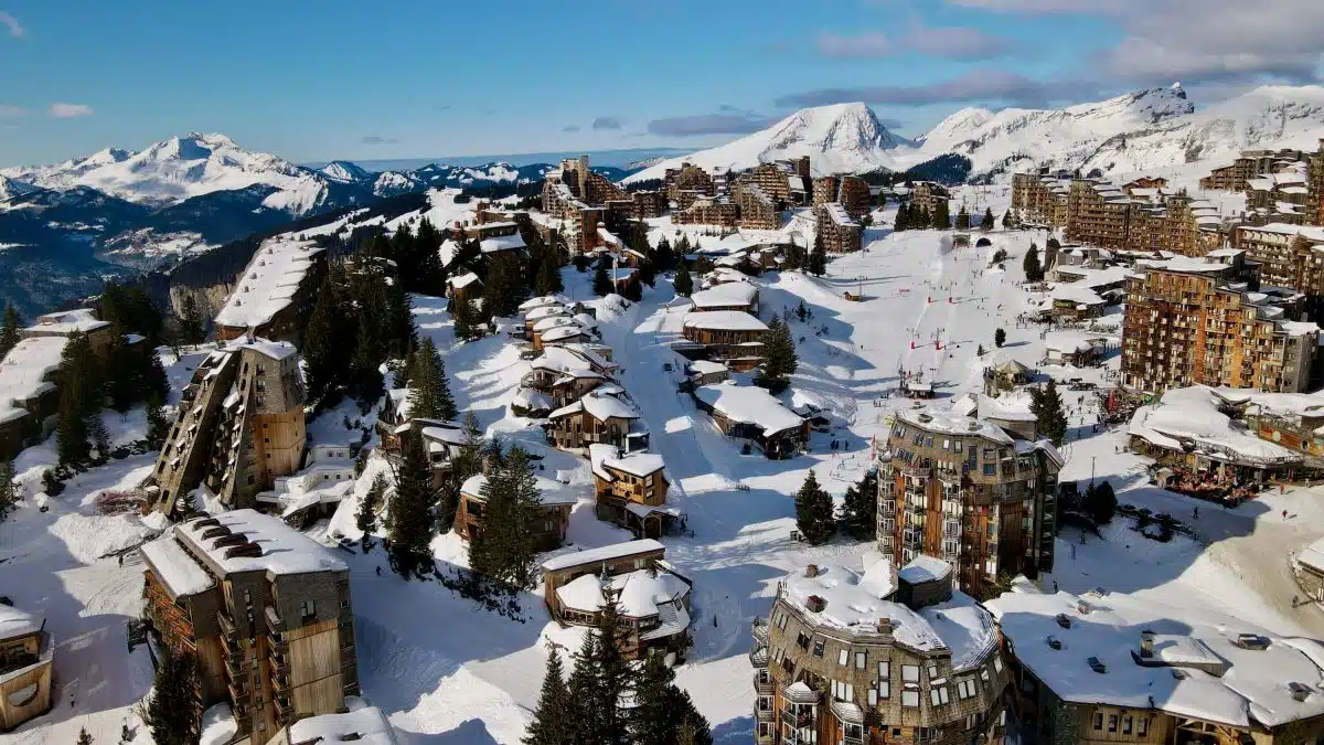 Les Portes du Soleil in Switzerland - a view of a snowy town with mountains in the background.