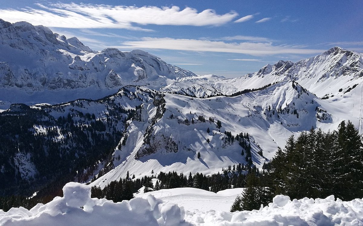 Les Portes du Soleil in Switzerland - a view of snow covered mountains from the top of a mountain.