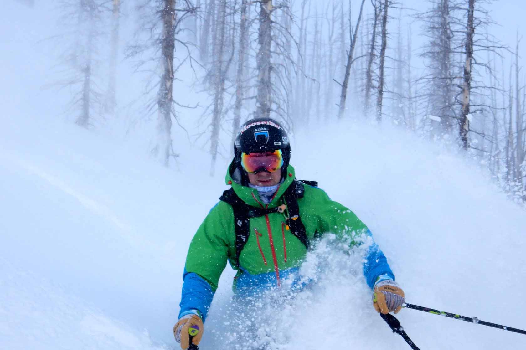 Teton Pass in USA - a person in a green jacket skiing down a hill.