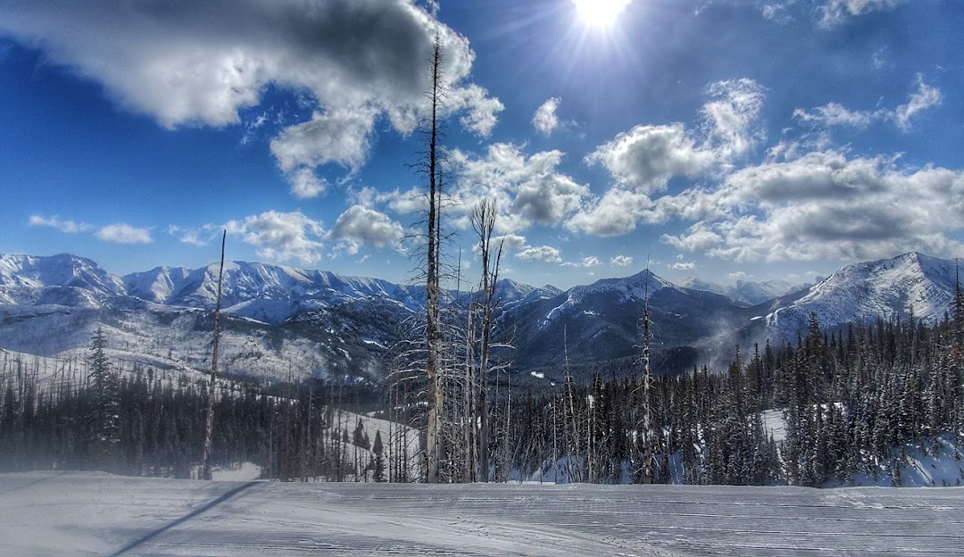 Skiers and snowboarders enjoying a winter sports day at Teton Pass in Choteau, Montana. The captivating winter scenery is dotted with a ski lift belonging to the local ski resort.