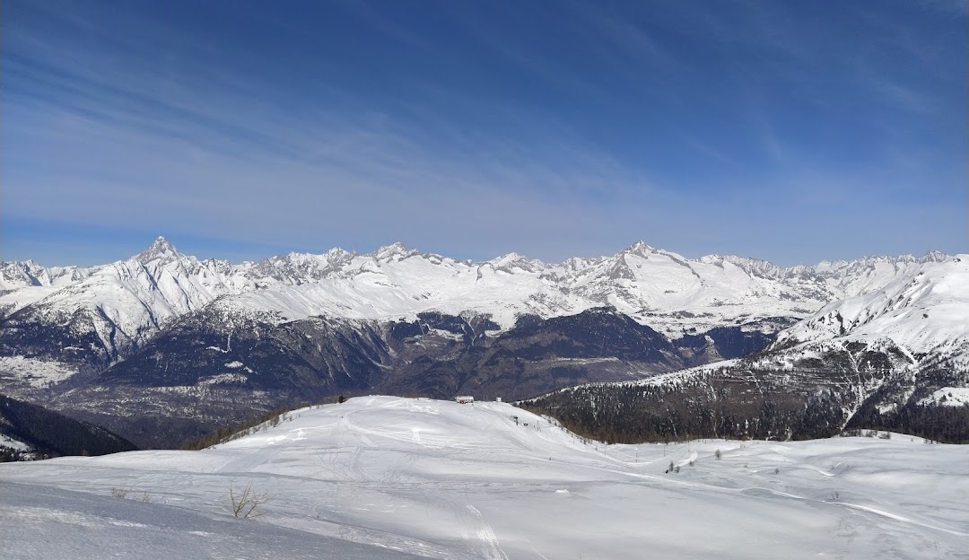 Image of a chalet nestled in Rothwald, a ski resort in Switzerland, with a winter sports scene actively taking place. Visible elements include skiers enjoying the mountain slopes.