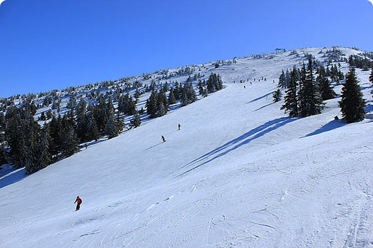 Winter scene at Pilsko-Korbielów, featuring a challet and ski resort in Korbielów, Silesia, Poland. A skier is seen enjoying the snow-covered slopes.