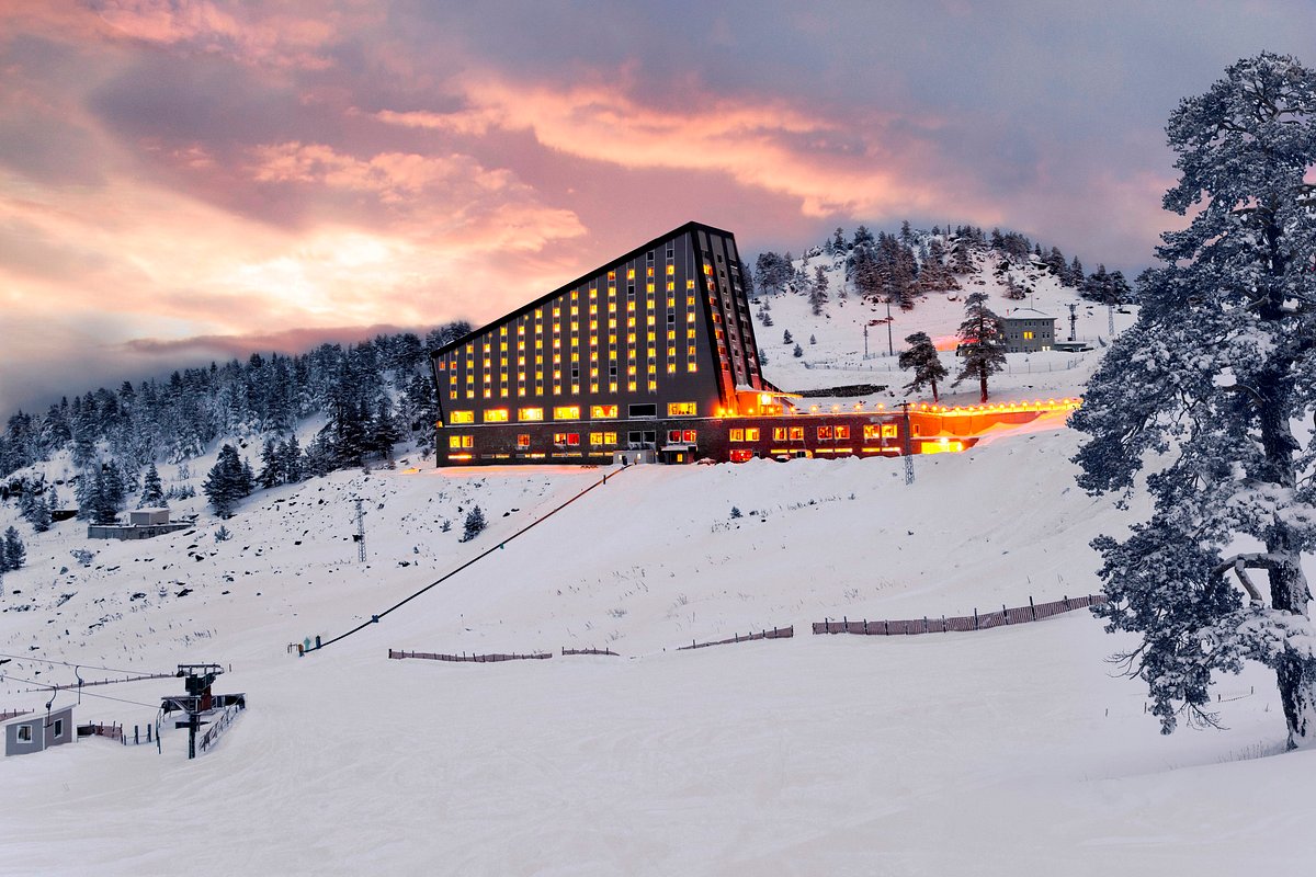 DorukKaya Ski & Mountain Resort in Turkey: the hotel on a snowy mountain at sunset.
