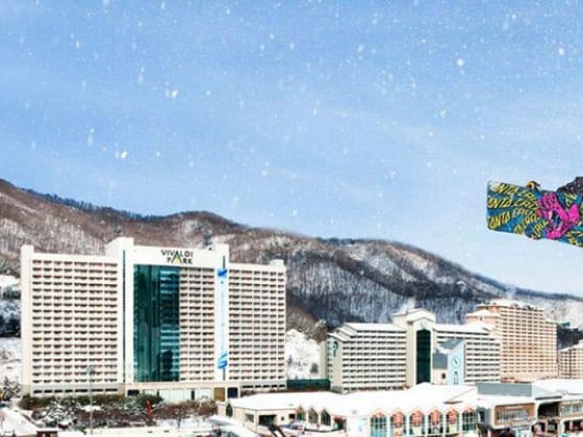 Vivaldi Park in South Korea - a snowboarder is in the air over a city.