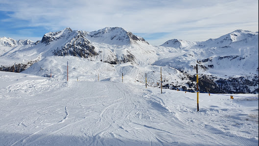 A picturesque winter scene at the Skigebiet und Minschuns ski resort in Eastern Switzerland featuring a charming chalet a bustling ski center and a skier enjoying the slopes.