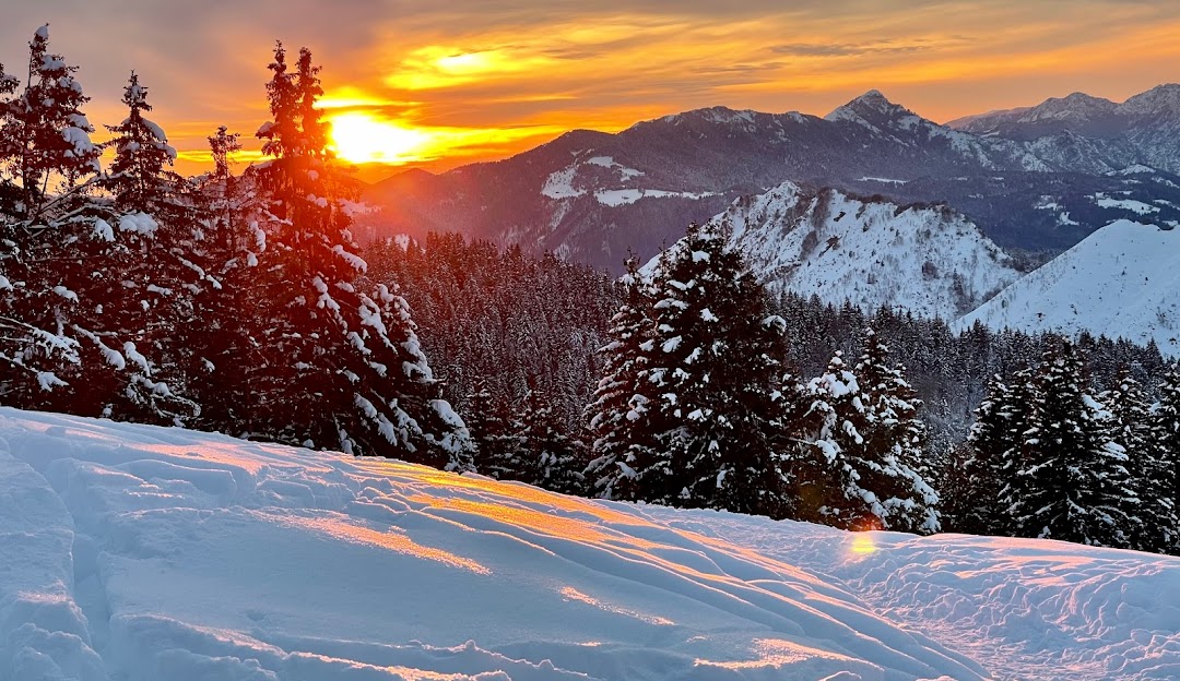 Winter sports enthusiasts enjoying a sunny day at Monte Pora ski resort in Lombardy, Italy. The picturesque backdrop of snow-covered mountains and clear blue skies adds to the stunning winter scenery.
