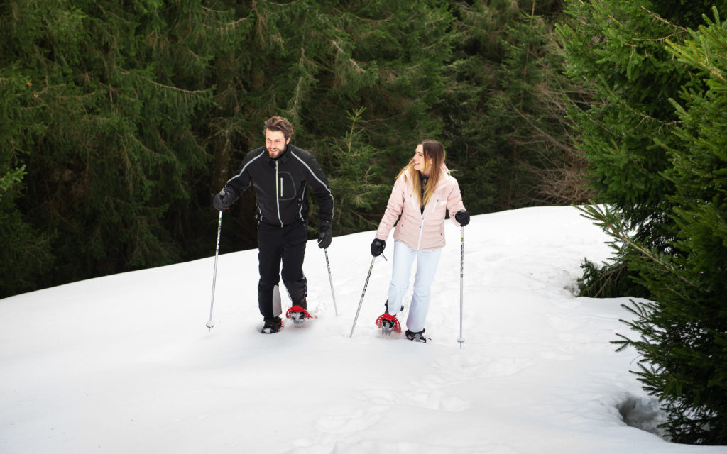 A family enjoying a day of winter sports at the Monte Pora ski resort in Lombardy, Italy, with a charming chalet in the background.
