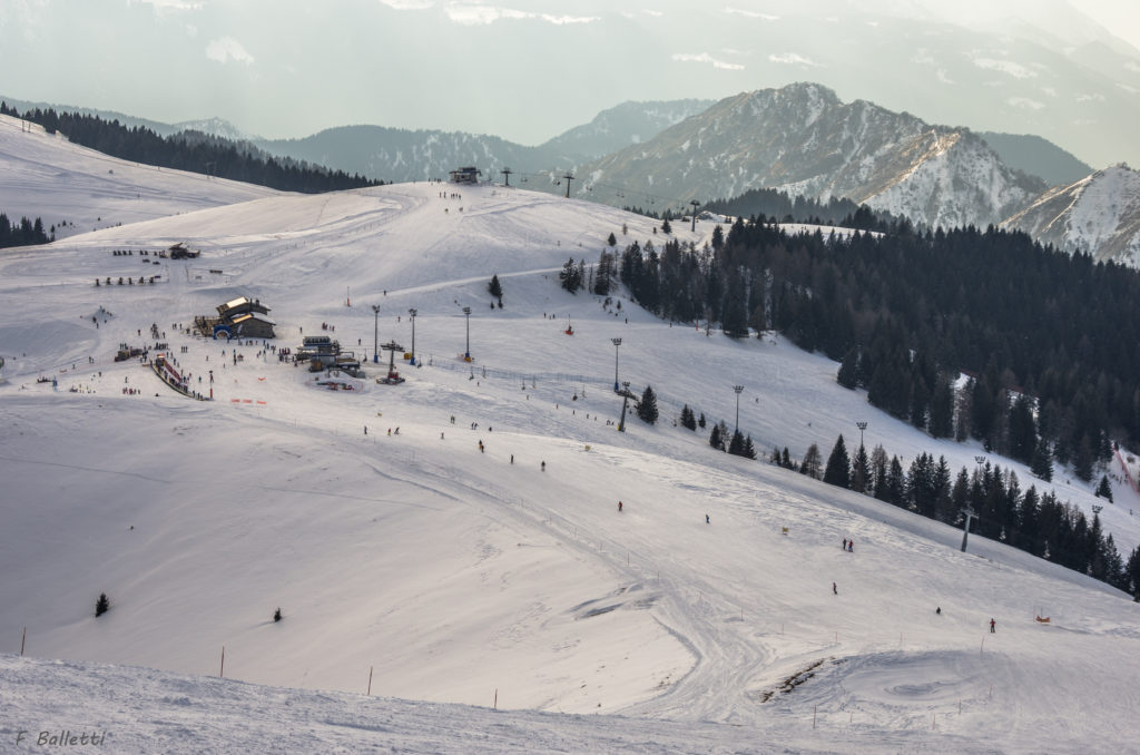 A winter sports scene at Monte Pora ski resort in Lombardy Italy featuring snow-covered slopes and a charming chalet.
