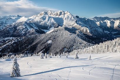 Winter scene at Monte Pora ski resort in Lombardy, Italy. It showcases a skier amidst the snow-covered slopes. A challet is also slightly visible in the picturesque winter backdrop.