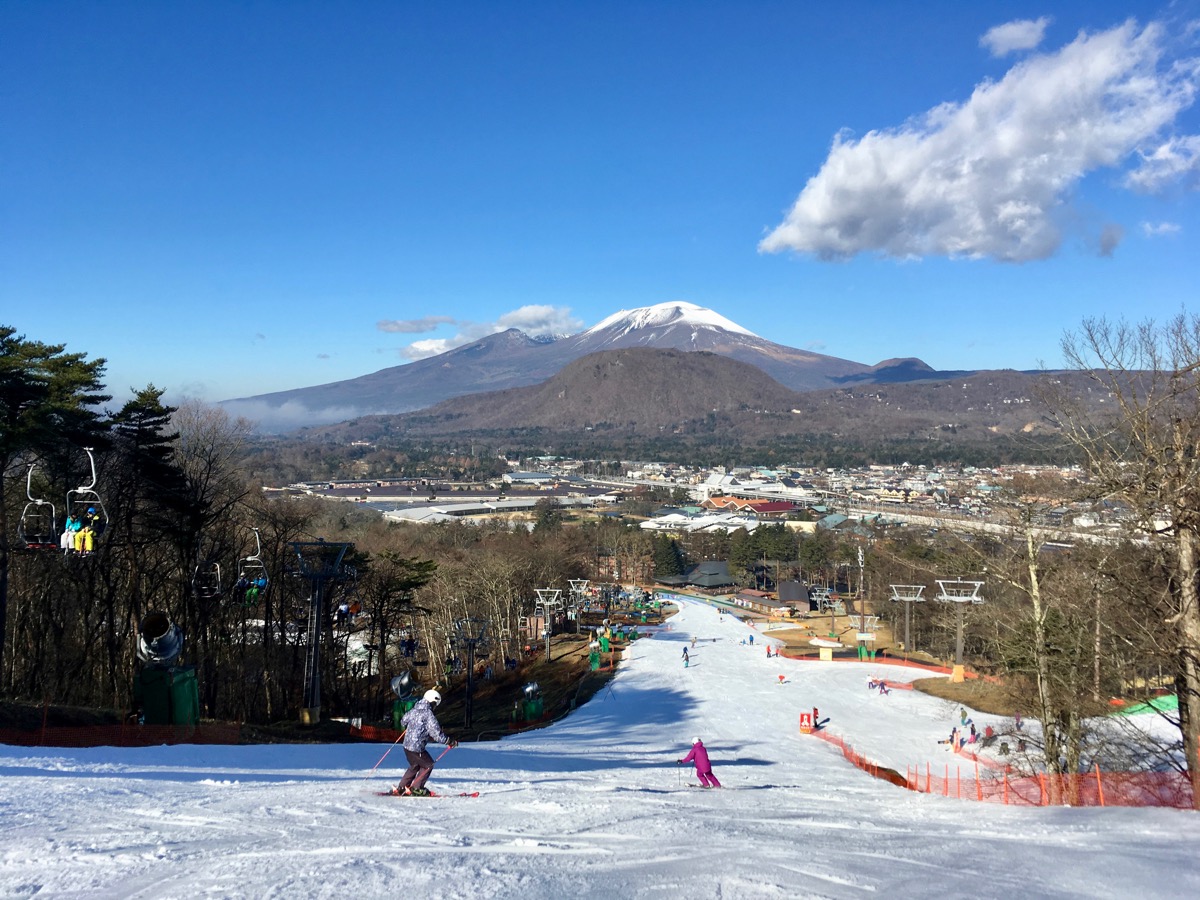 Karuizawa in Japan - a person skiing down a hill on a sunny day.