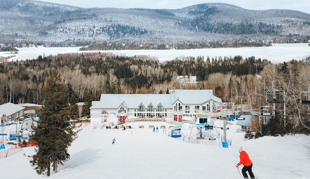 Winter scene at Ski La Réserve, Lanaudière, Quebec, featuring a bustling ski resort amidst the stunning, snow-covered landscape, bustling with skiers enjoying their winter sport.