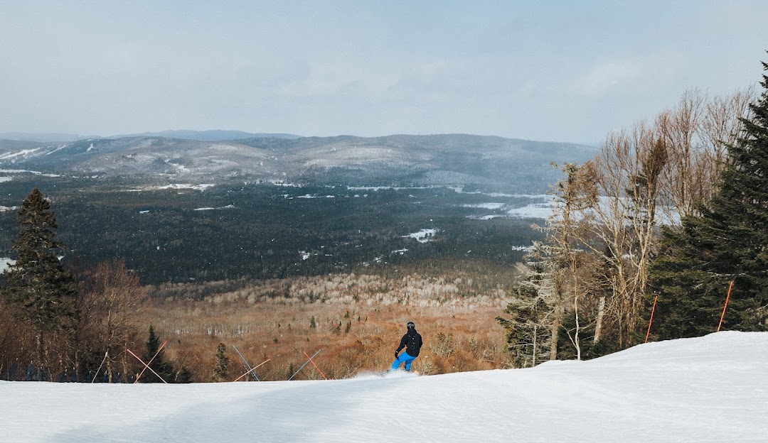 Winter sports scene at Ski La Réserve in Quebec, Canada featuring a skier making their way down the mountain amid a scenic snowy ski resort landscape.
