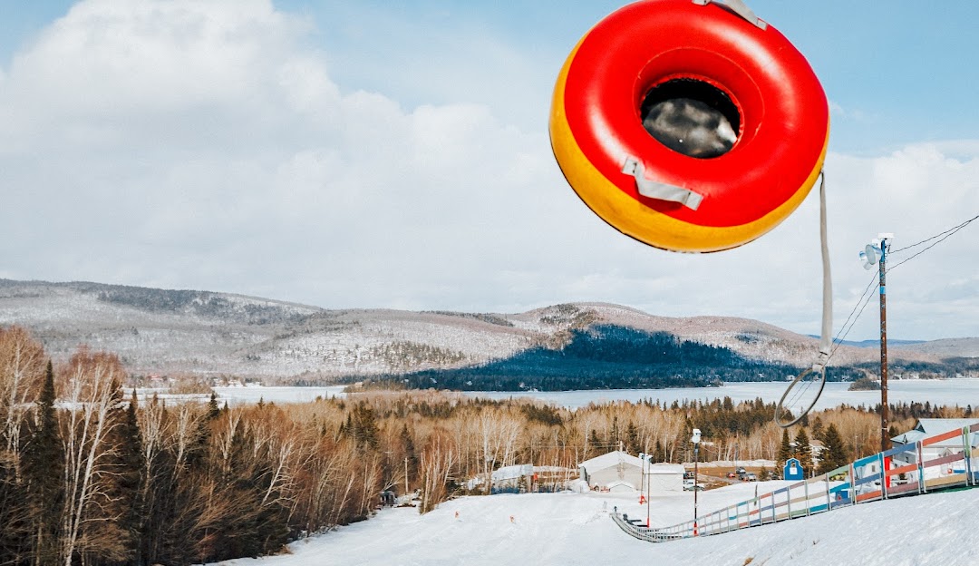 Winter scene at Ski La Réserve in Quebec, Canada featuring skiers and snowboarders navigating down the snowy slopes, depicting a vibrant winter sports scenario.