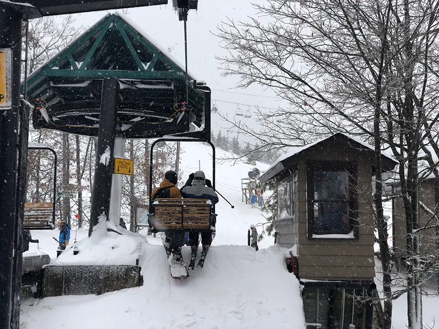 Caberfae Peaks in USA - a person riding a ski lift in the snow.