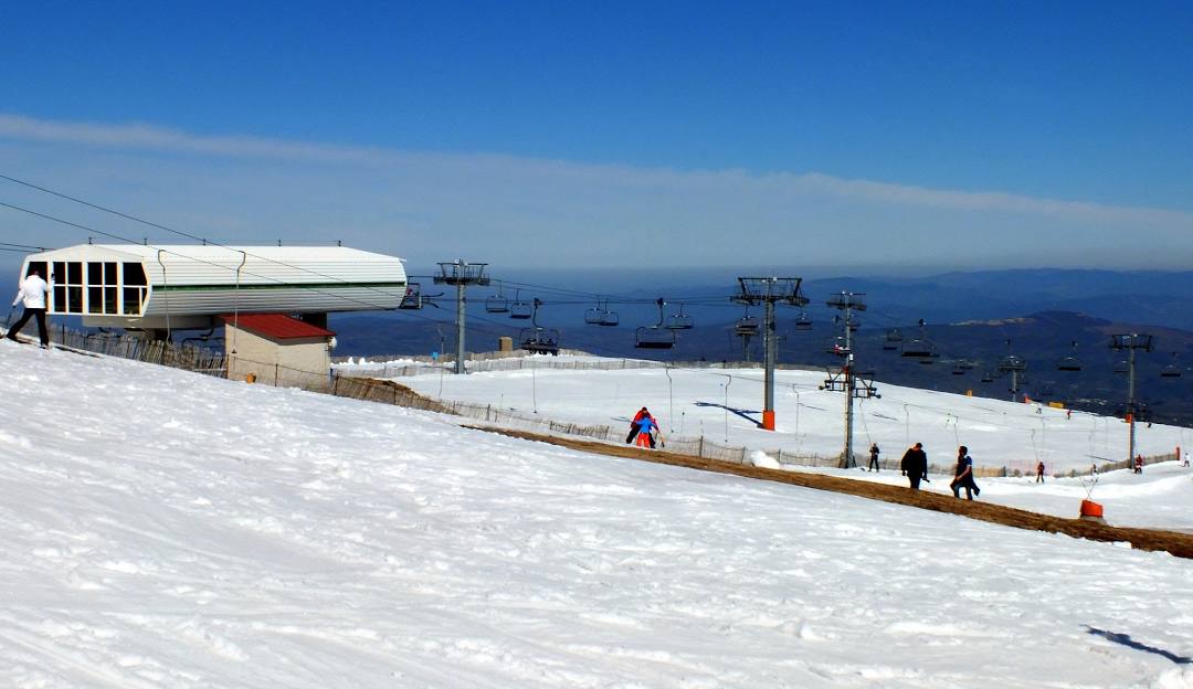 Winter sports scene in Manzaneda Ourense Spain featuring a bustling ski resort with a ski lift amidst breathtaking winter scenery.