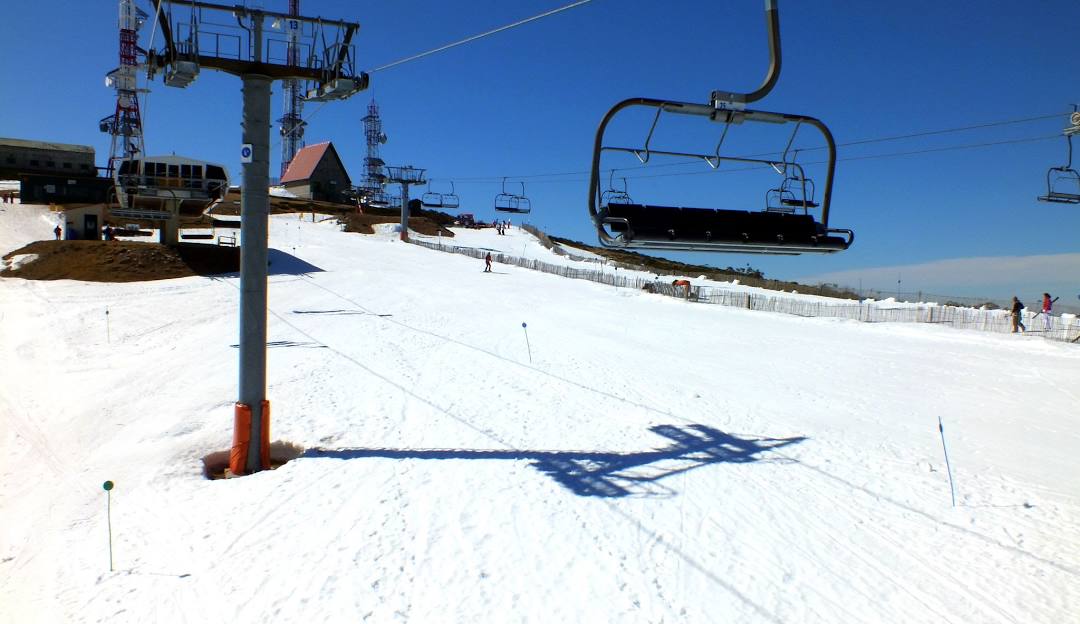 A skier at Manzaneda ski resort in Ourense Spain. The scene captures the ski lift slope and nearby chalet amidst the winter sports activities.