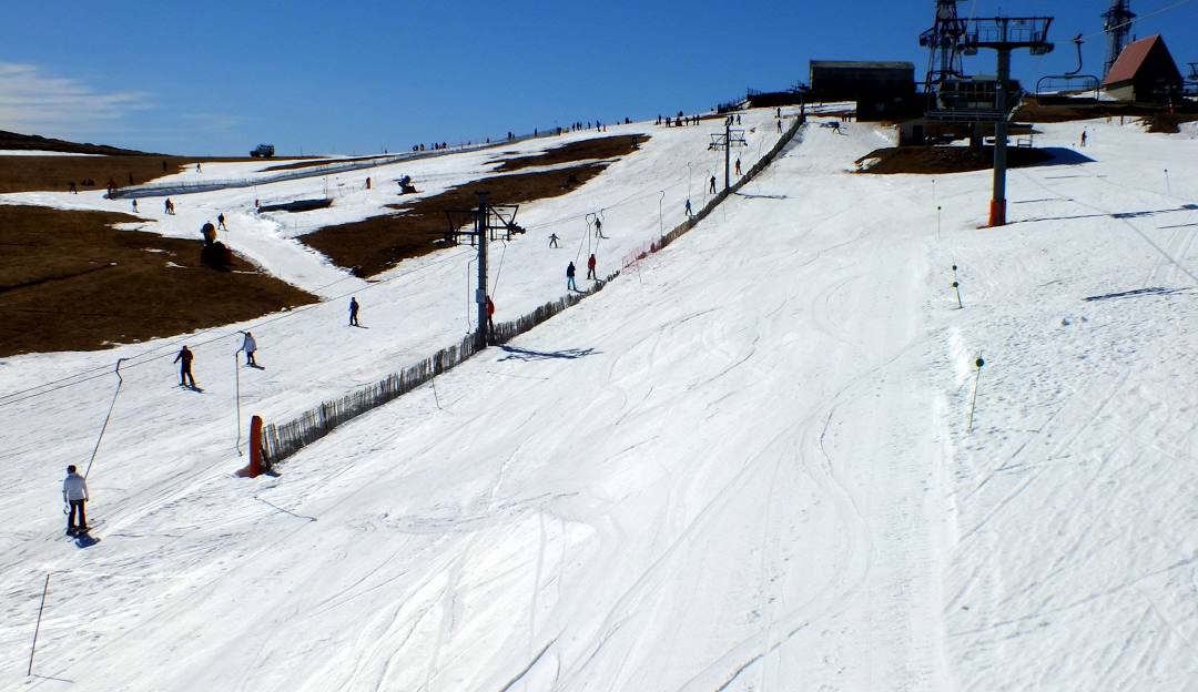Ski resort in Manzaneda, Ourense, Spain featuring a vibrant winter sports scene. Picture showcases snow-covered slopes and a ski lift ascending the mountain.