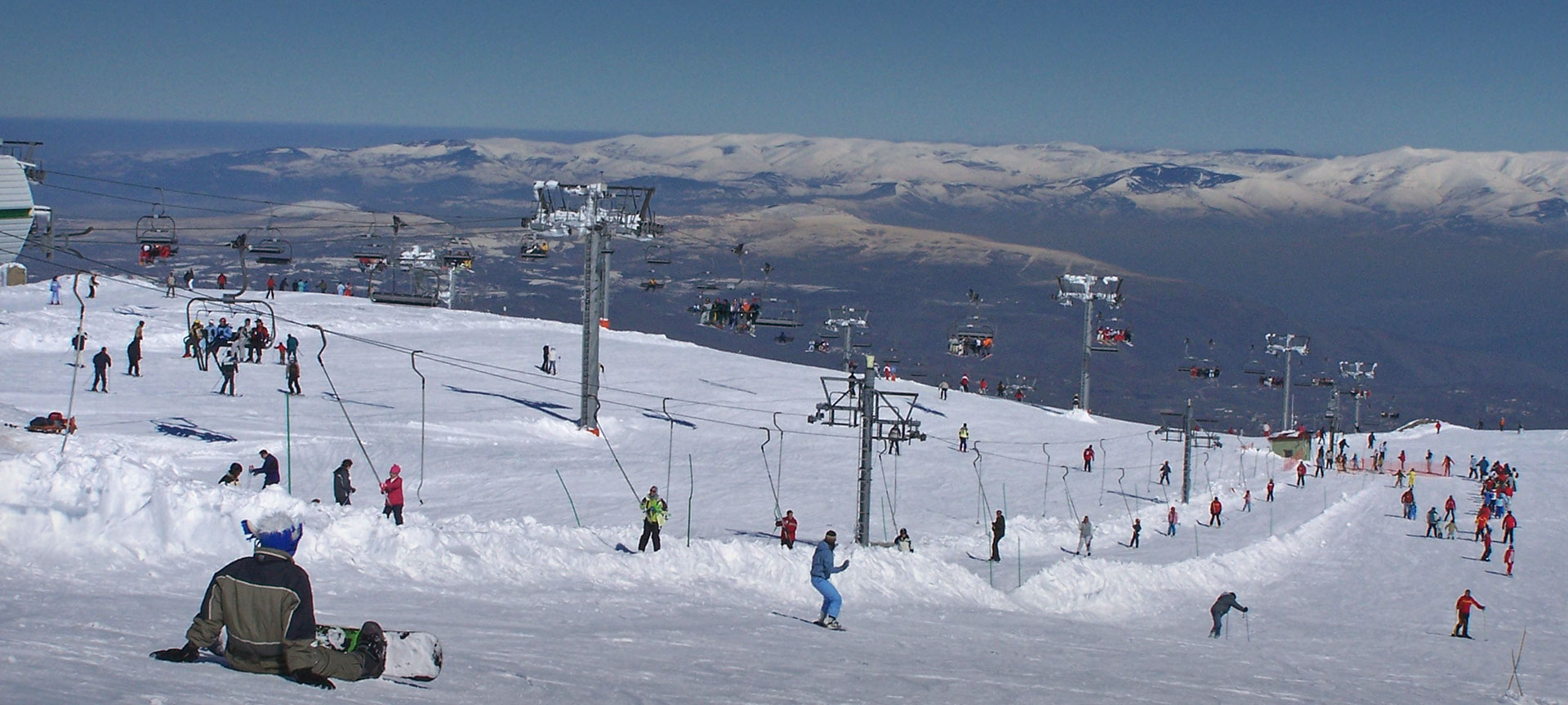 Manzaneda in Spain - a group of people skiing down a snowy hill.