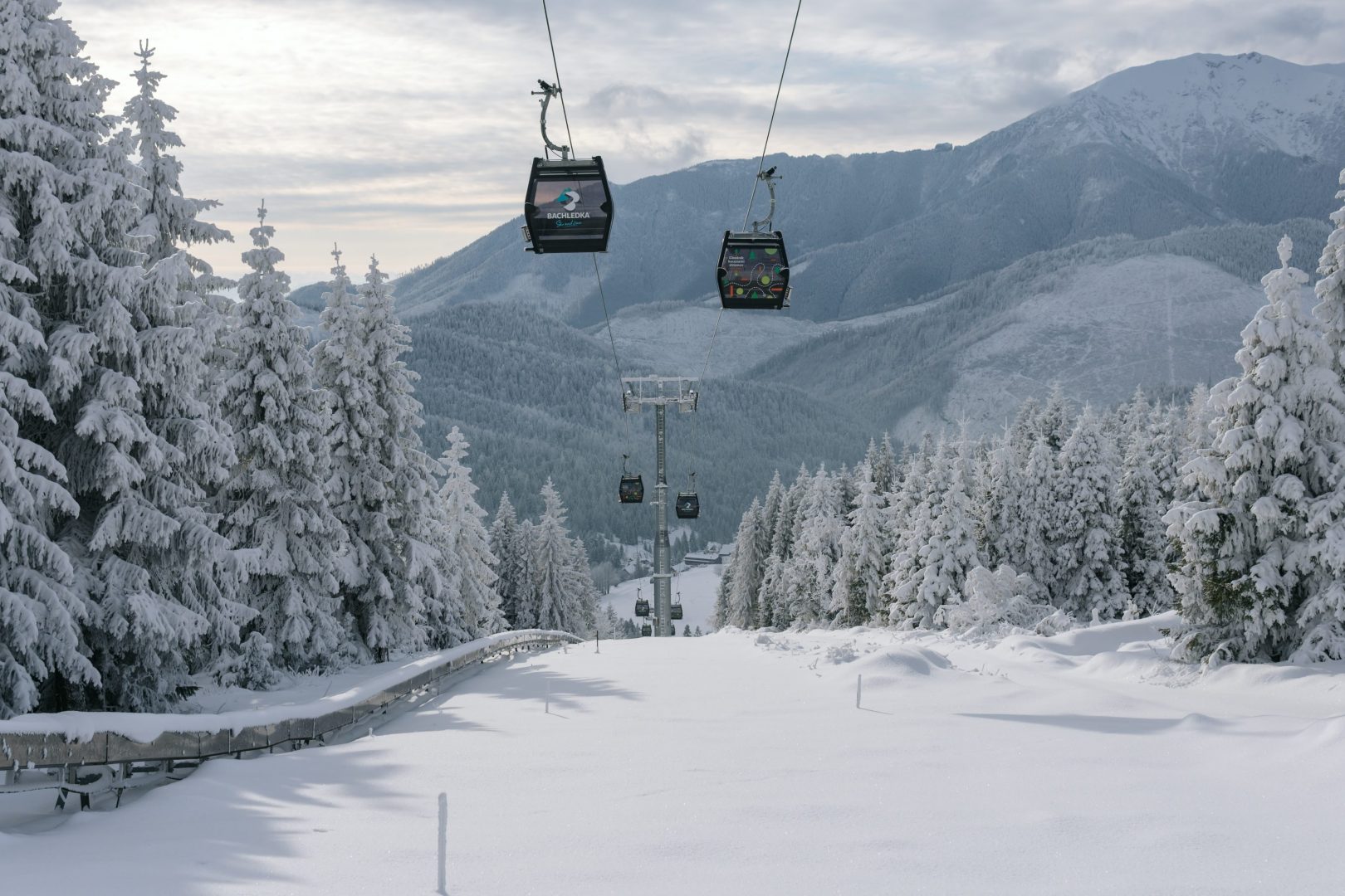 Ski Jezersko - Bachledova dolina, Sedačková lanovka in Slovakia - a ski lift going up a snowy mountain.