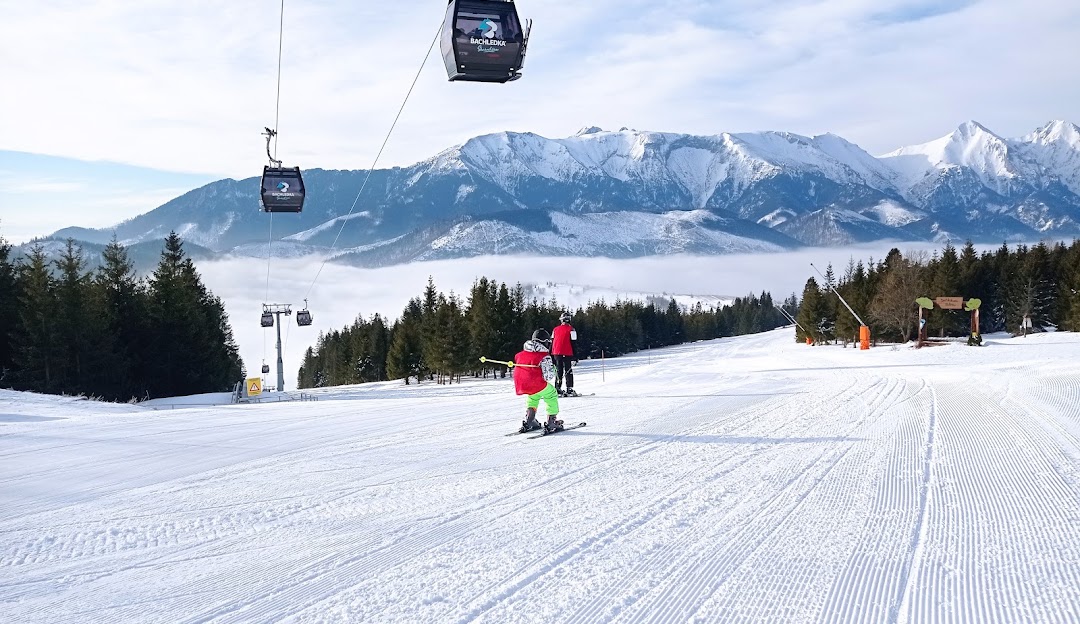 Winter sports enthusiasts enjoying a day at Ski Jezersko - Bachledova dolina. The scene features skiers using the ski lift at this popular ski resort in Prešov, Slovakia.