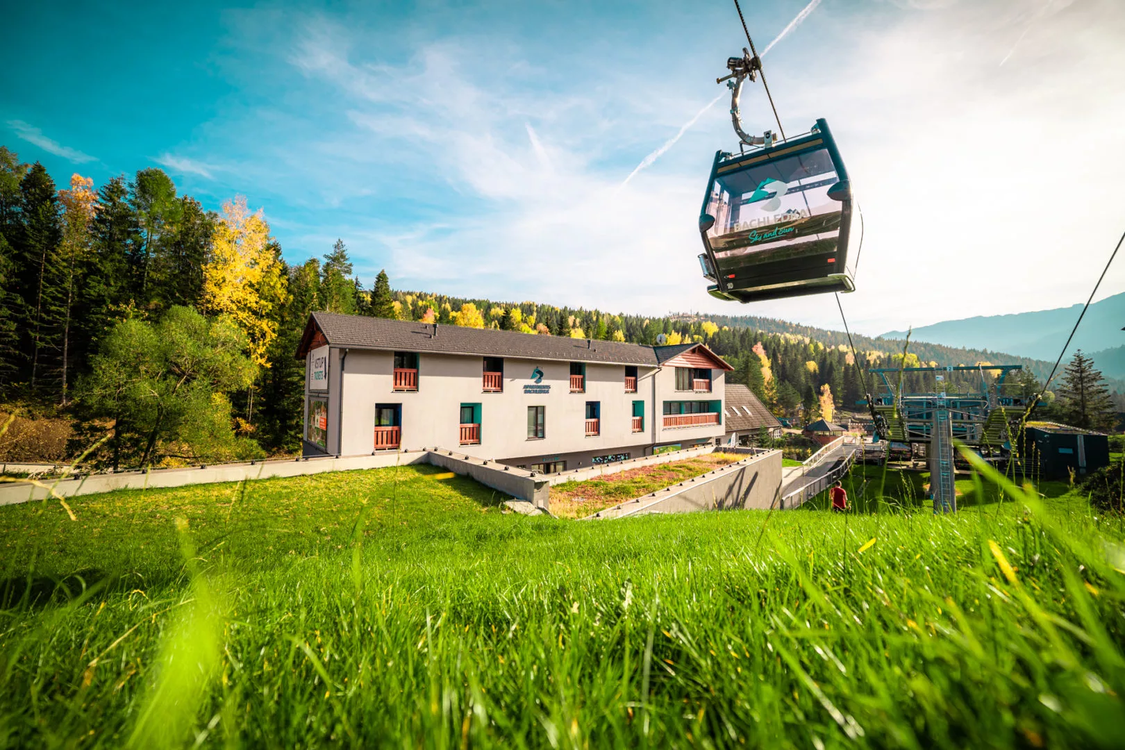 Ski Jezersko - Bachledova dolina, Sedačková lanovka in Slovakia - a cable car going up the side of a house.