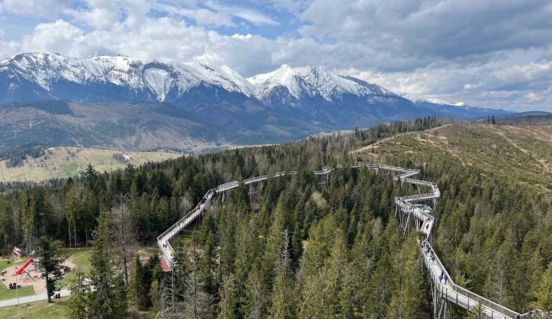 Ski lift at Ski Jezersko Resort in Slovakia, with mountains providing a scenic backdrop. Winter sports enthusiasts enjoy the snowy terrain near a cozy chalet.