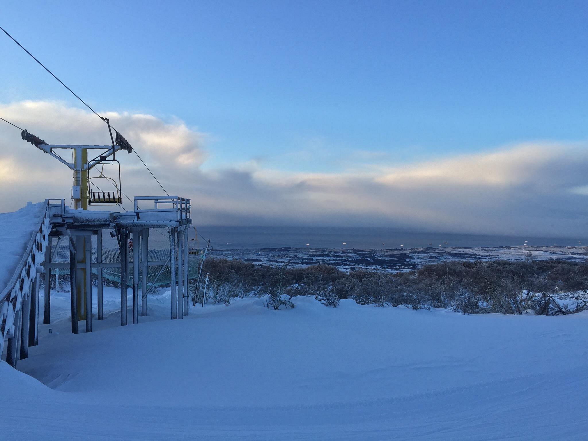 View of Club Andino ski resort in Chile featuring a bustling winter sports scene. A ski lift silently glides across a remarkable winter landscape.