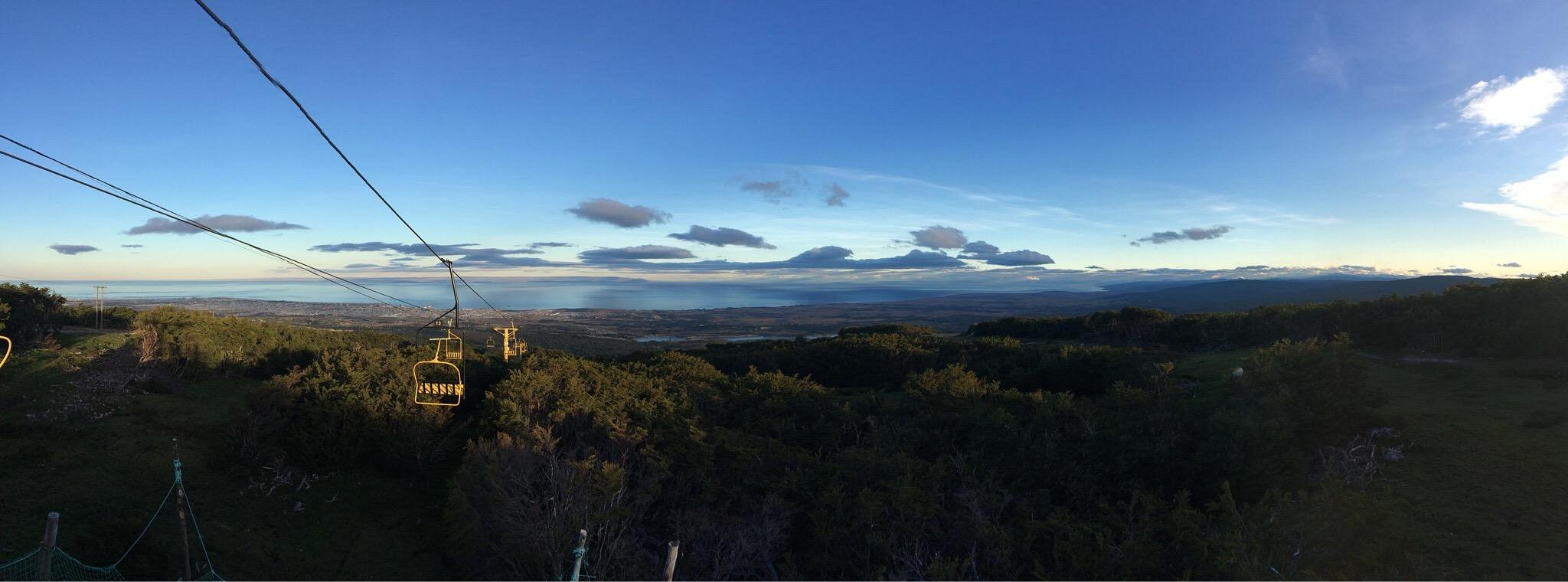 View of the stunning Club Andino, nestled at the base of Cerro Mirador mountain in Punta Arenas, Chile. A charming chalet is visible on a sunny winter day, and a mountain bike adds a sense of adventure.
