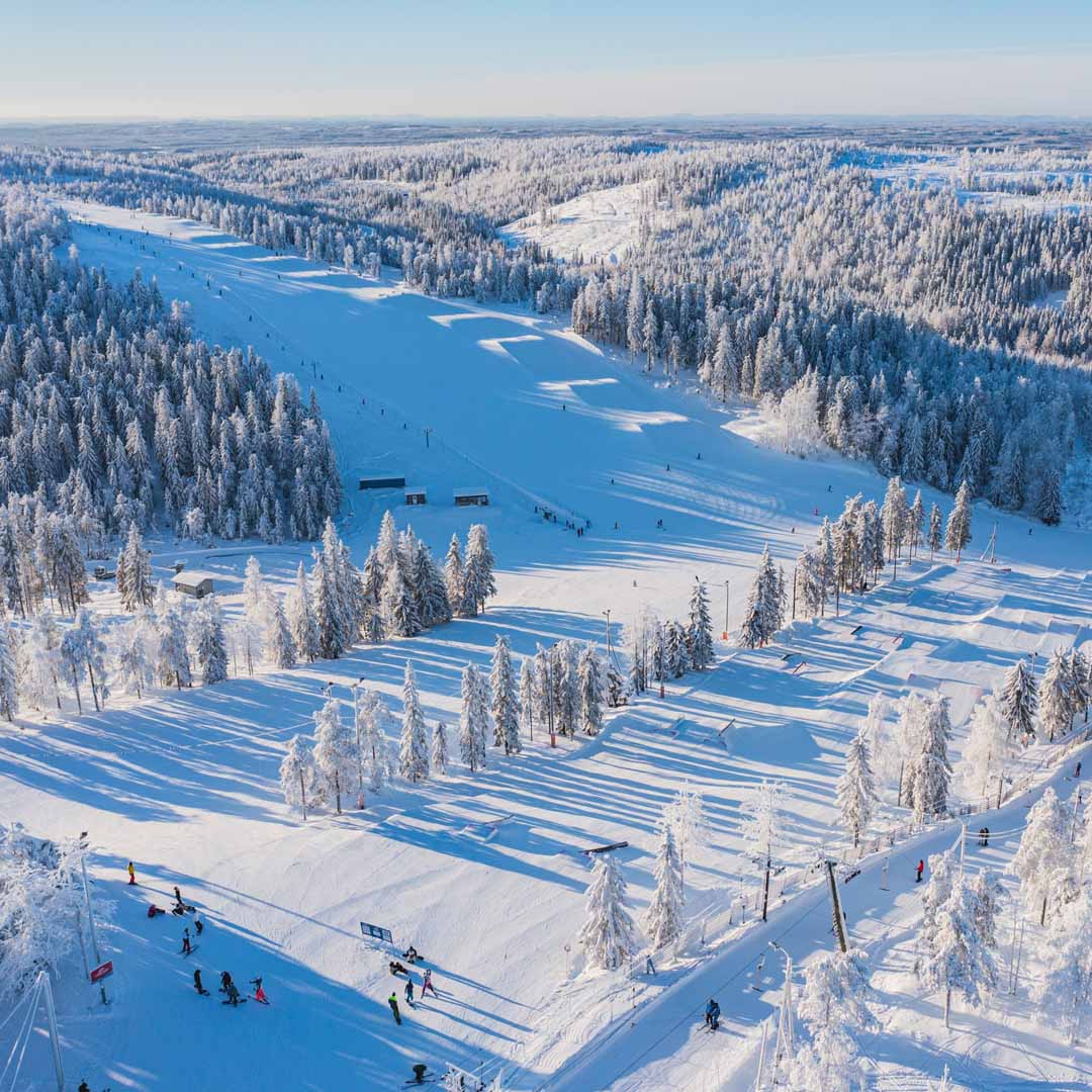 Winter sports scene at Tahko a ski resort in Kuopio Finland showcasing stunning winter scenery with snow-covered slopes pine trees contrasted against the clear sky.