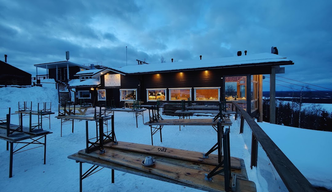 Winter scene at Tahko ski resort in Finland, featuring a sports centre and a cozy chalet amongst a snow-covered landscape.