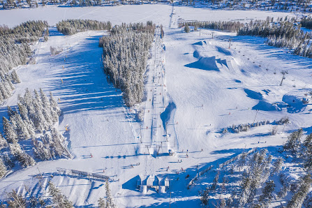 Winter sports scene at Tahko ski resort in Kuopio East Finland showcasing skiers enjoying the snow-covered slopes with a ski lift in the background.