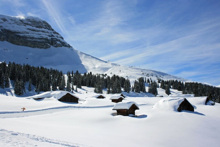 A breathtaking view of Axalp Tschingellift in Bernese Oberland, Switzerland. A winter sports scene reveals a bustling ski resort nestled amidst stunning winter scenery.