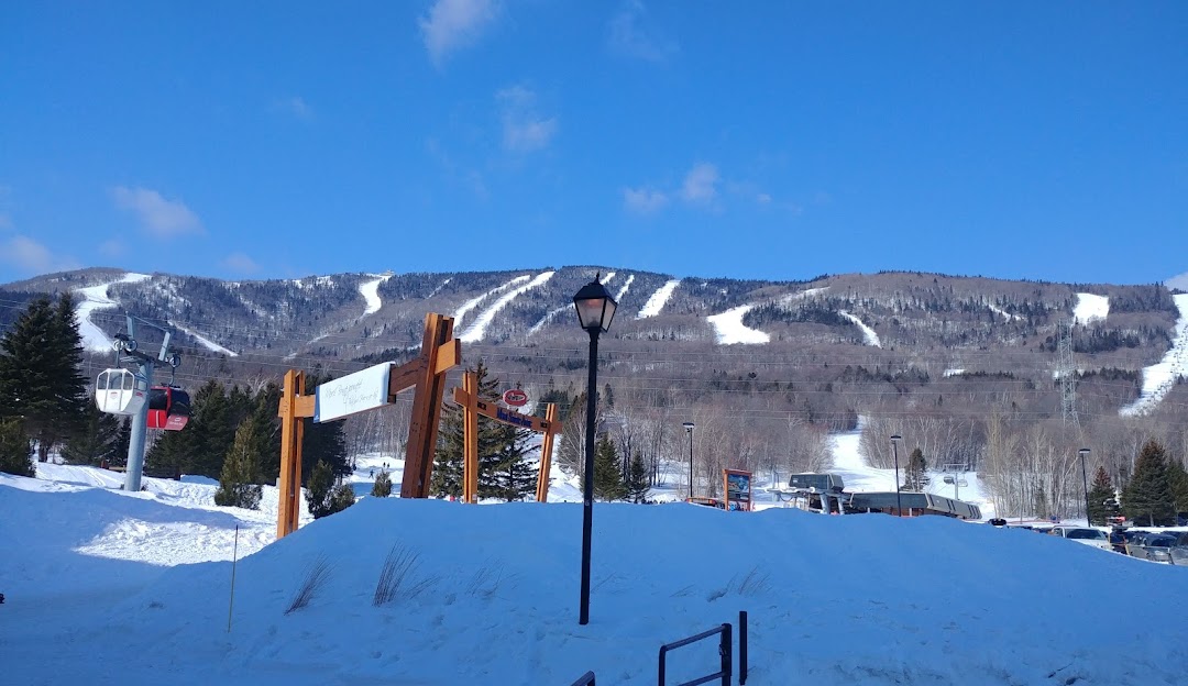 Mont-Sainte-Anne in Canada - a snow covered ski slope with a mountain in the background.