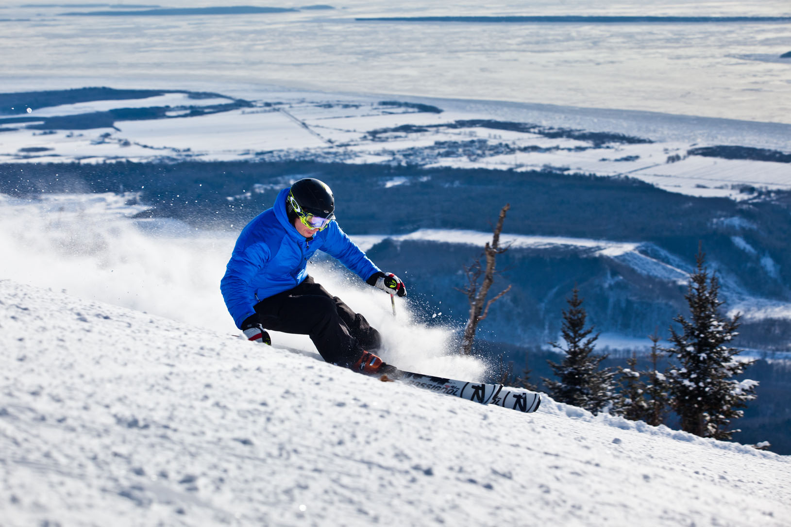 Mont-Sainte-Anne in Canada - a man in a blue jacket skiing down a hill.