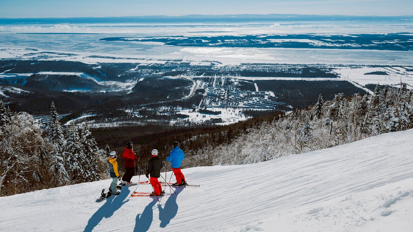 Mont-Sainte-Anne in Canada - a group of people skiing down a mountain.