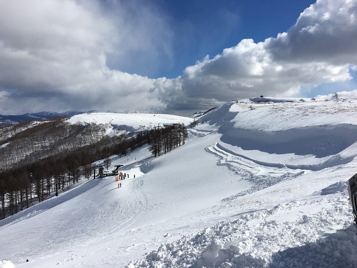 Echo Valley in Japan - a person standing on top of a snow covered mountain.