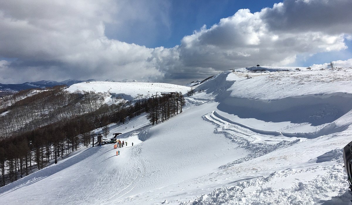 Echo Valley in Japan - a person standing on top of a snow covered mountain.