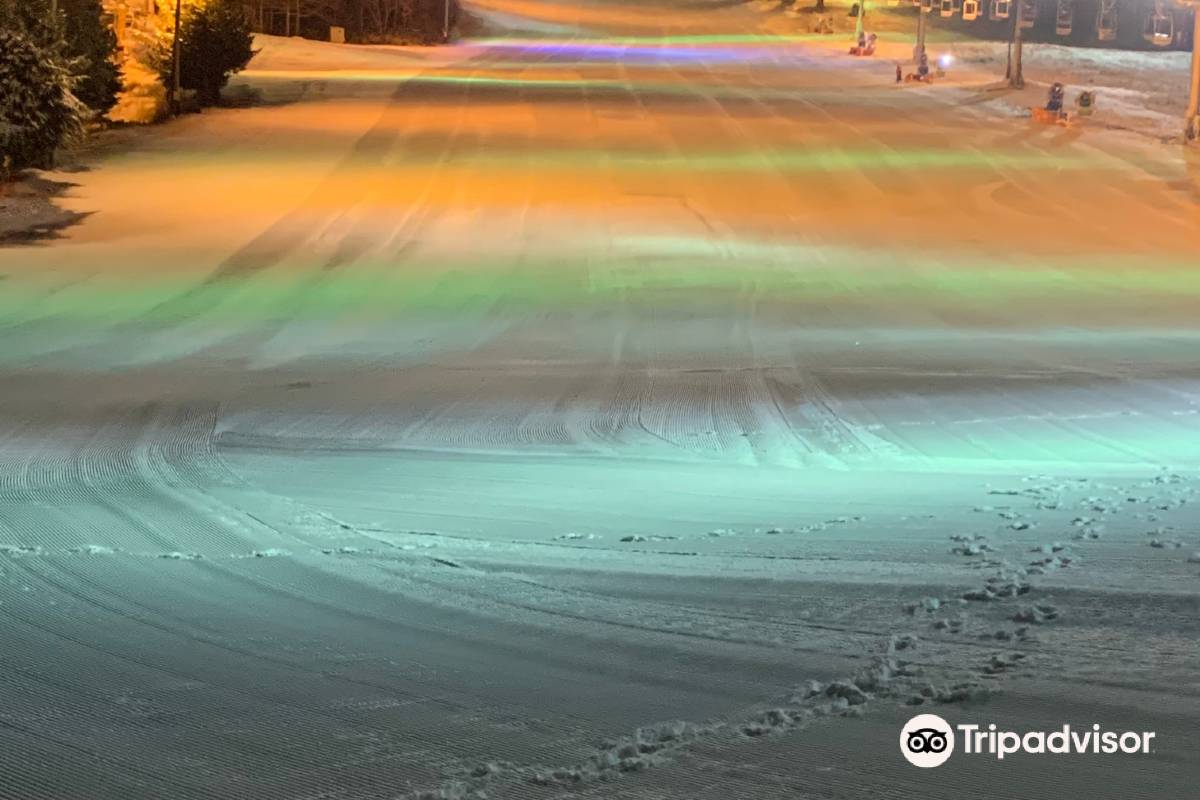 Winter sports enthusiasts enjoy a vibrant day at Echo Valley, Nagano, Japan. The scene is adorned with a snowmobile, complexities of a ski resort, and breathtaking winter scenery all around.
